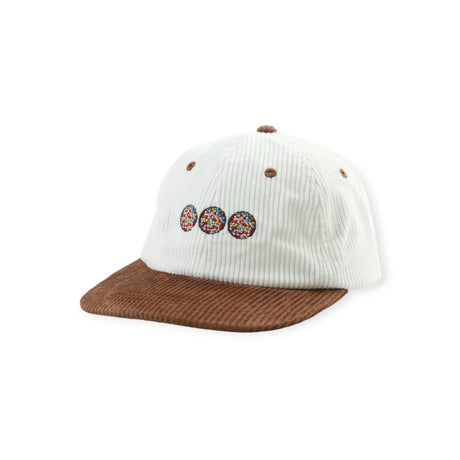 White corduroy cap with brown brim and three colorful circular embroidered designs on front panel