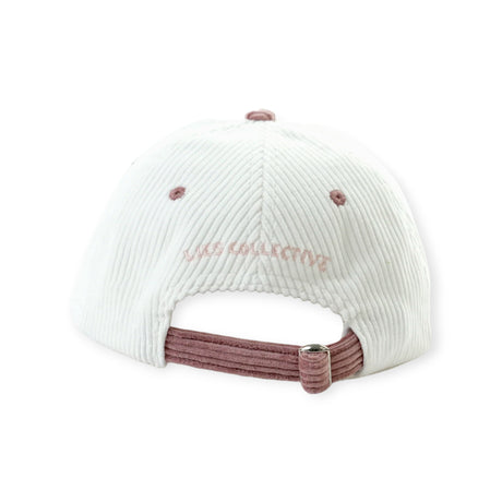 Back view of cream corduroy cap with dusty pink adjustable strap and Lies Collective embroidered text above opening
