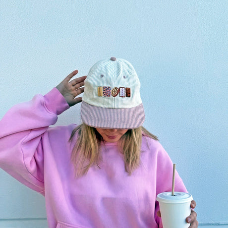 Cream corduroy cap with pale pink brim featuring embroidered classic Aussie biscuit designs on front panel