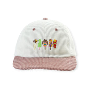 White ribbed knit hat with mauve corduroy-style brim and colorful embroidered characters on front