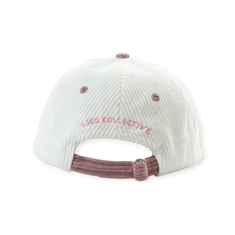 Back view of white corduroy hat with dusty rose adjustable strap and pink Lies Collective embroidery above opening