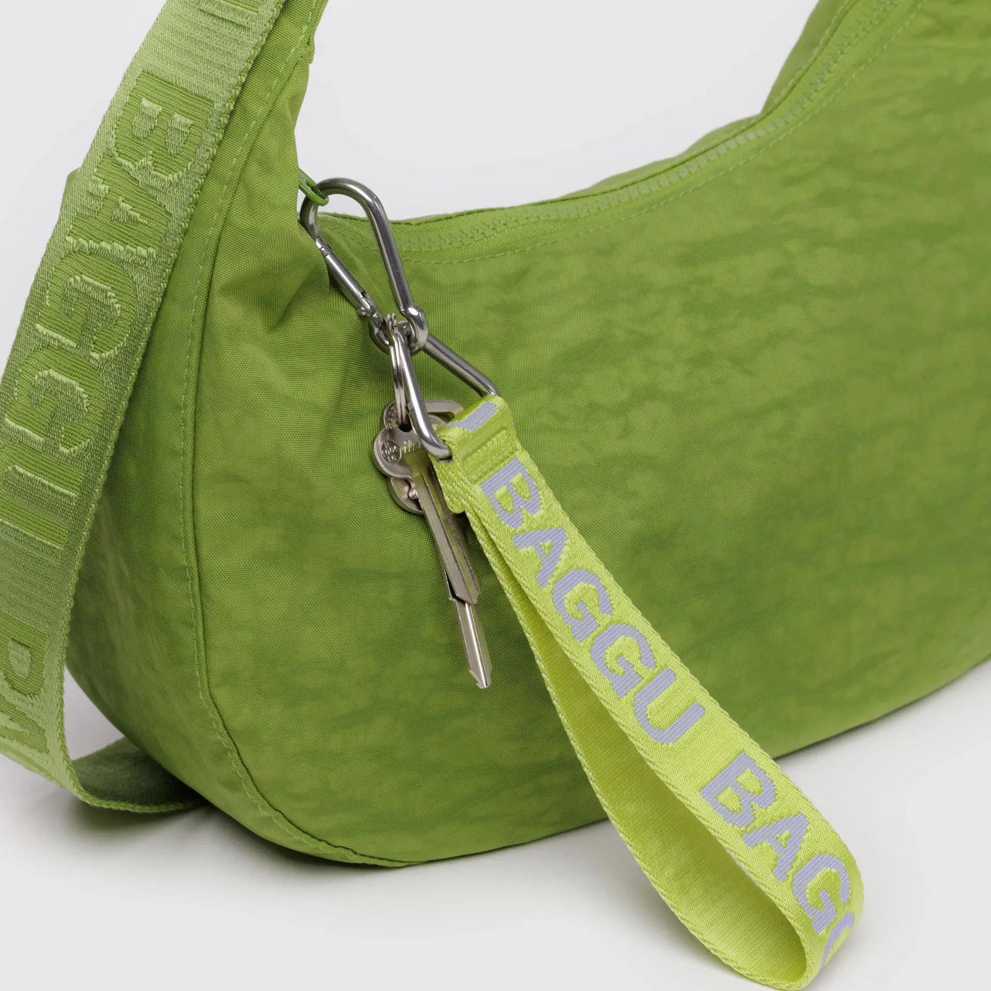 Citron green keychain strap with Baggu logo text and silver clip attached to bag