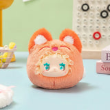 Plush Lovely Emma Rua Rua Zoo bag charm in orange fox costume with ruffled hood and large blue eyes on pastel background