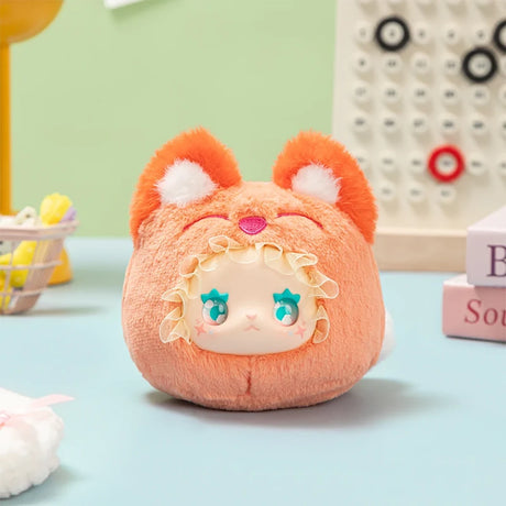 Plush Lovely Emma Rua Rua Zoo bag charm in orange fox costume with ruffled hood and large blue eyes on pastel background