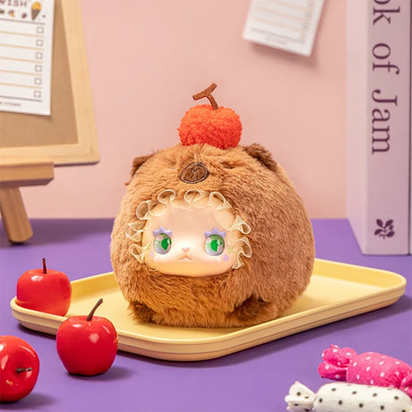 Round plush Lovely Emma Rua Rua Zoo bag charm in brown bear costume with green eyes and red pom-pom on yellow tray