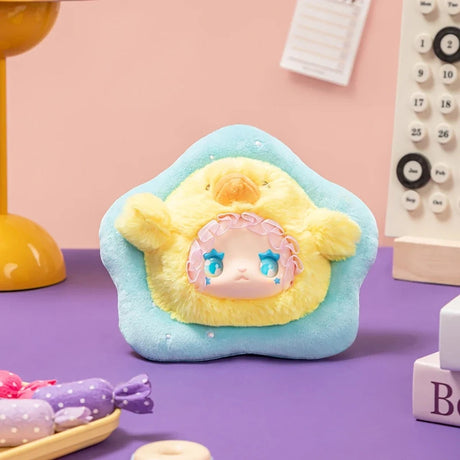 Plush Lovely Emma Rua Rua Zoo bag charm in yellow chick costume with blue star-shaped eyes on blue star-shaped cushion background