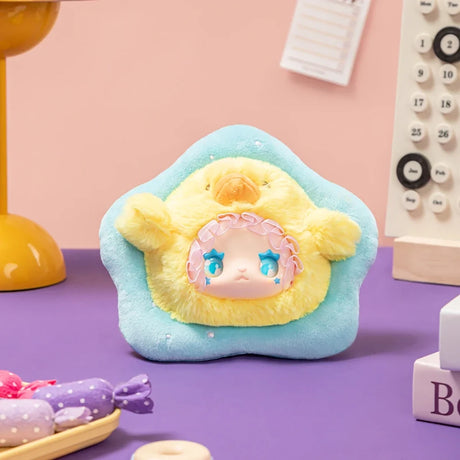 Plush Lovely Emma Rua Rua Zoo bag charm in yellow chick costume with blue star-shaped eyes on blue star-shaped cushion background