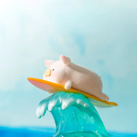 LuLu the Piggy figurine riding a translucent blue wave on an orange surfboard against a sky background