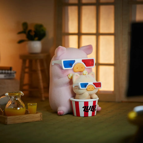 Pink LuLu the Piggy figurine and cat in 3D glasses with popcorn bucket on table near juice in cozy room