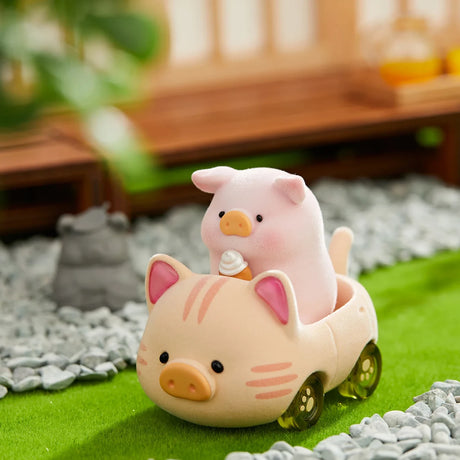LuLu the Piggy figurine holding an ice cream cone, sitting inside a pig-shaped toy car on a grassy surface