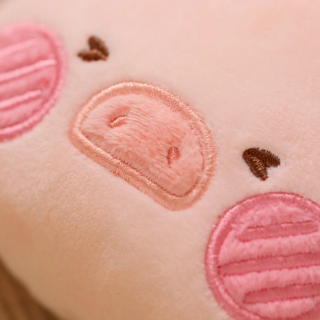 Close-up of soft plush LuLu the Piggy pouch with embroidered snout, pink cheeks, and heart-shaped brown eyes detail