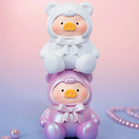Two LuLu The Piggy - Mini Teddy Blind Bag figures, by LuLu The Piggy, in white and pink bear costumes are stacked together on a pink-purple gradient background, with shimmering pearls adding extra charm to the scene.