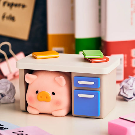 Piggy blind box figure beside a desktop with blue drawers in an office setup