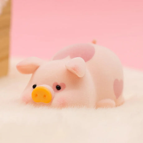 LuLu the Piggy Original Series 2 figure 3 with heart patterns and soft texture lying on fluffy white surface against pink background
