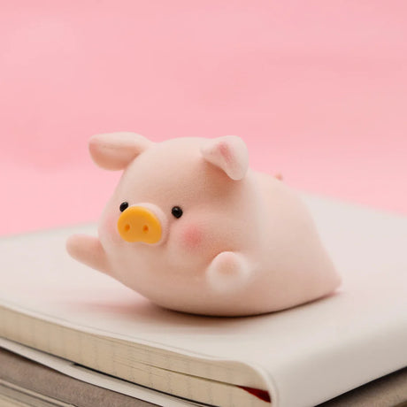 LuLu the Piggy Original Series 2 figure 5 in soft texture with yellow snout and blush lying on closed white book