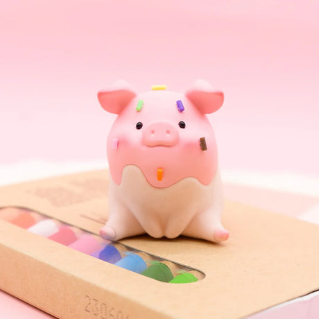 LuLu the Piggy Original Series 2 figure 7 with pink frosting and colorful sprinkles sitting on cardboard box with pastel background