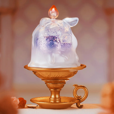 Translucent pig figurine with glitter inside atop a golden vintage-style candle holder with handle and saucer