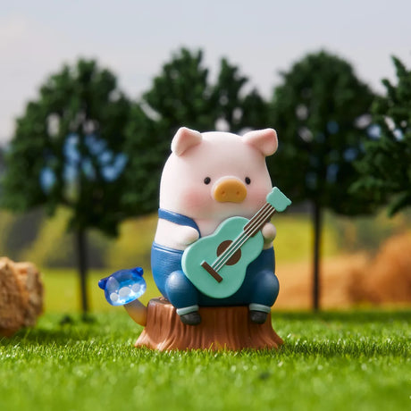 LuLu the Piggy figurine sitting on tree stump playing blue guitar with small blue mushroom on grass and trees background