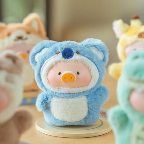 The Lulu The Piggy - Animal Party Puppet Keychain Blind Box by LuLu The Piggy features a plush toy pig in a blue koala costume, standing on a round base. Add vibrant charm to your collection with these adorable blind box keychain figures.