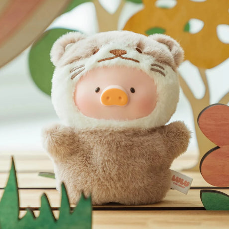 A LuLu The Piggy - Animal Party Puppet Keychain Blind Box plush, featuring a pig face in a bear costume, from the LuLu The Piggy brand, sits on wood with colorful shapes in the background.