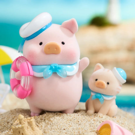 A pig and a cat figurine in sailor outfits, with a pink and white lifebuoy and sandcastle, stand on the beach—fun ocean adventure toys from the LuLu The Piggy - Ocean Blind Box by LuLu The Piggy.
