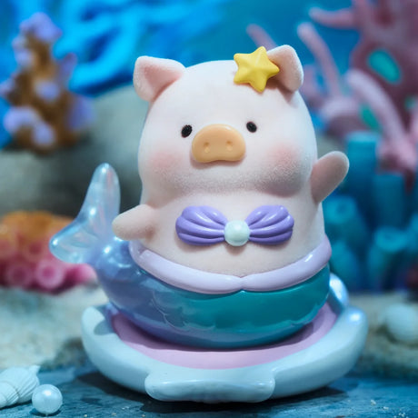 A LuLu The Piggy - Ocean Blind Box figurine of a pig in a purple seashell top, shiny mermaid tail, and yellow star headpiece, shown underwater with coral. From the LuLu The Piggy brand.