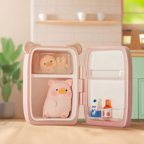 A small, pink LuLu the Piggy - Stay With You Blind Box by LuLu The Piggy featuring collectible figures and tiny milk and juice bottles on the door shelf, displayed on a kitchen counter.