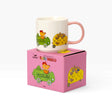 White ceramic mug with pink handle on pink box, busy world vehicle illustrations