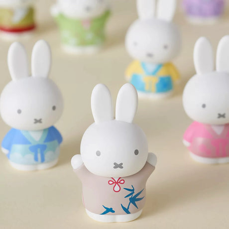Miffy blind box bunny figurines, three white rabbits with blue and pink clothing, close-up
