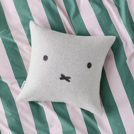 Light gray wool cushion cover with black Miffy-style face on a square pillow