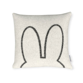 The Miffy Cushion Cover - Premium Wool by Miffy features a minimalist black outline of two upright bunny ears on white, plus a side fabric tag for added charm.