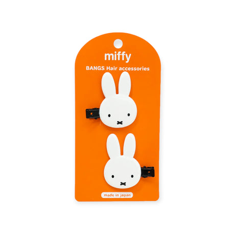 Orange package card showing two white bunny hair clip accessories with black snap clips