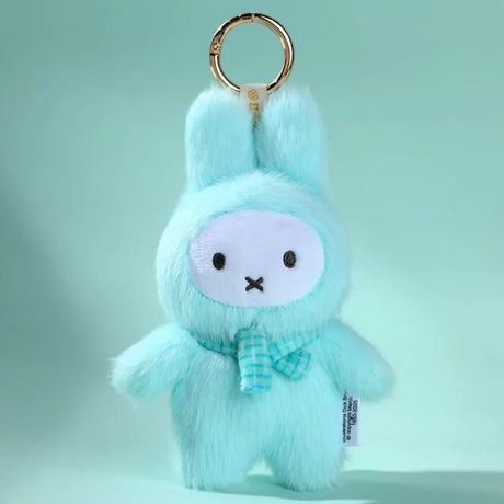 The VIPO x Miffy Macaron 2 Plush Keychain - Blind Box by Miffy, featuring a light blue design with a bow tie and stitched details, is displayed on an aqua background.