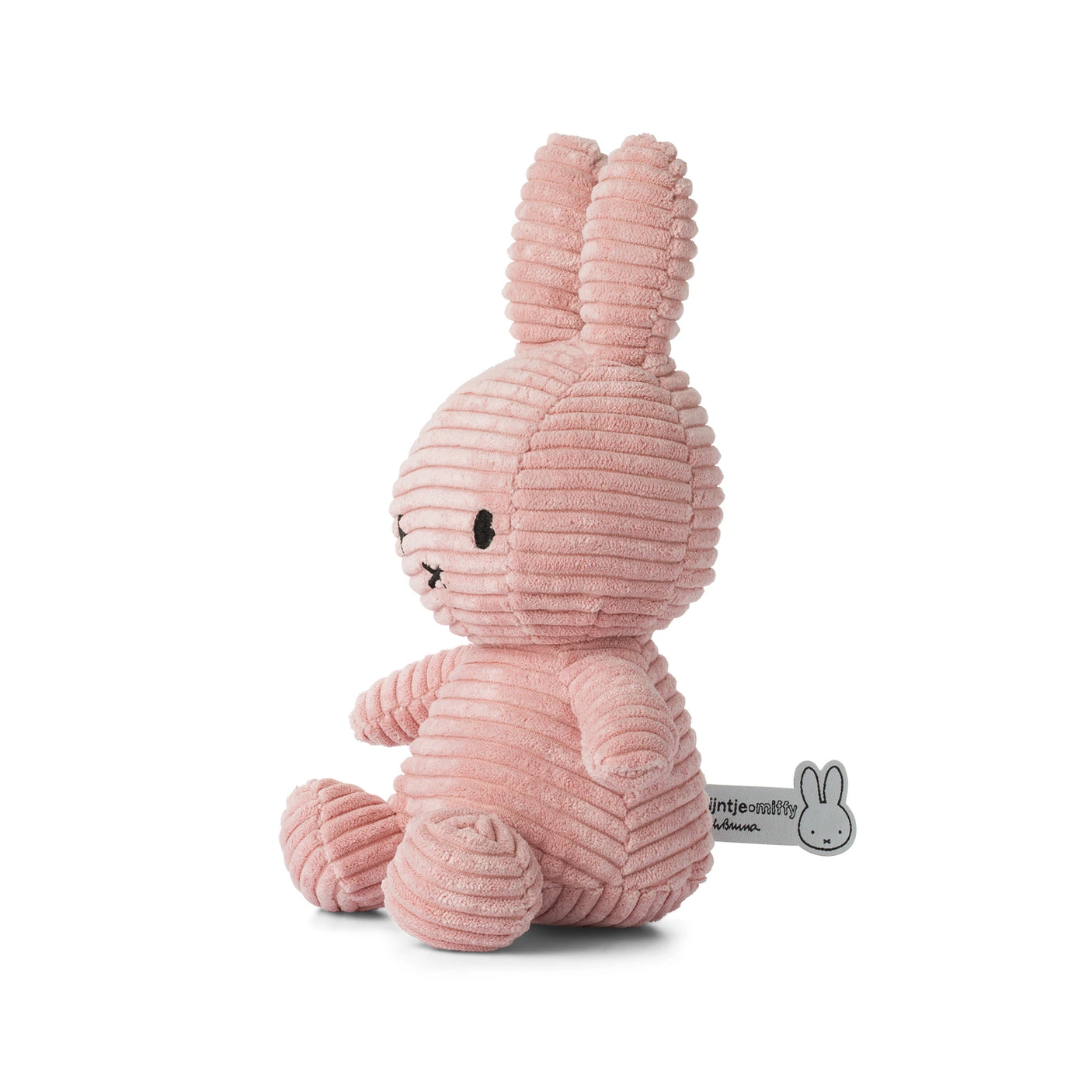 Side view of the Miffy Bunny Plush Corduroy in pink, featuring a ribbed texture and long ears with a side label. This 23cm plush from the Miffy brand is baby-safe and perfect for cuddles.