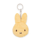 The Miffy Plush Flat Keychain - Corduroy features a yellow bunny head design made from corduroy, with long ears and simple facial details, attached to a metal keyring.