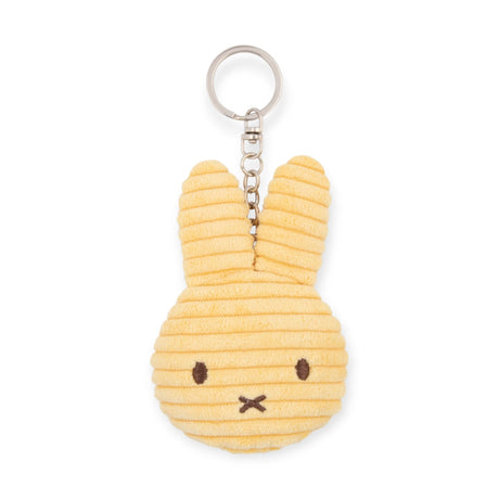 This off-white Miffy Flat Corduroy Keychain features a bunny head with long ears and a simple facial expression, made from ribbed corduroy fabric reminiscent of the classic plush keychain style.