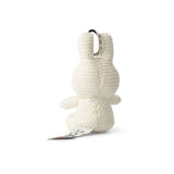 A plush Miffy Keychain Corduroy 10cm - Off-white, resembling a small bunny seen from the back with ribbed texture, eco-friendly design, and an attached paper tag.