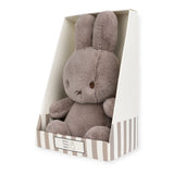 A Cozy Miffy Plush & Gift Box Taupe - 23cm bunny toy by Miffy, crafted from recycled polyester and seated upright in a striped gift box.