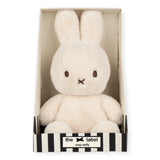 The Cozy Miffy Plush & Gift Box Cream - 23cm is a plush white bunny toy with long ears and a small face, nestled in a striped gift box. Made by the brand Miffy, it features super soft fabric.