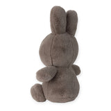 A plush, cozy taupe Miffy bunny from the brand's collection is crafted from recycled polyester, sitting with its back towards the viewer and highlighting its long ears and round tail.