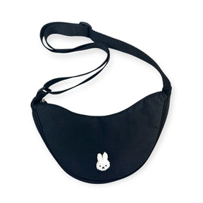 Front view of black Miffy Crescent Crossbody Bag featuring minimalist white Miffy face embroidery and adjustable strap, gallery 1
