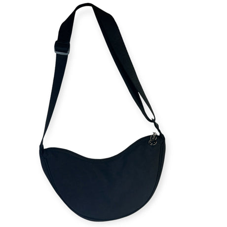 Black Miffy Crescent Crossbody Bag hanging against white background showing smooth crescent shape and adjustable strap