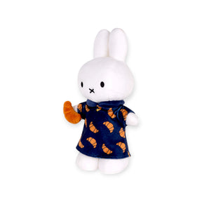 Side view of Miffy plush wearing croissant-print dress and holding a plush croissant snack, gallery position 1