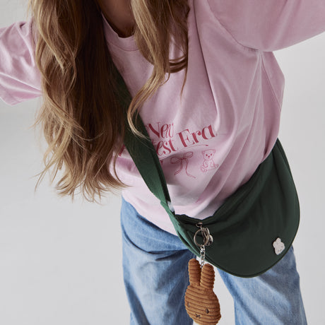 Person wearing green Miffy Crescent Crossbody Bag with brown plush charm visible, promo image 2 in gallery