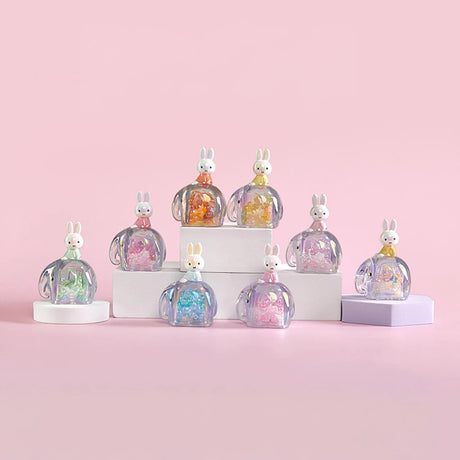 Nine translucent elephant-shaped snowglobes with varied colorful beads and Miffy figures atop pastel pink background