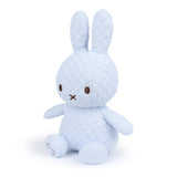 A quilted eco-friendly stuffed bunny in light blue, featuring long ears, sits upright against a white background, evoking the charm of the Miffy Quilted Plush Gift Box - Blue 23cm by Miffy.