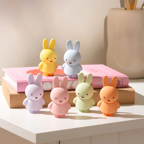 Smoko x Miffy Goes Pastel - Blind Box with six pastel-colored Miffy bunny figures by Miffy on white table near books