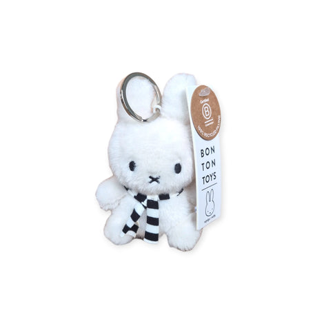 This Miffy Keychain Plush, measuring 10cm, is eco-friendly and white, designed in the shape of a Miffy Bunny wearing a striped winter scarf. It includes an attached tag featuring "Bon Ton Toys," emphasizing its handmade quality.