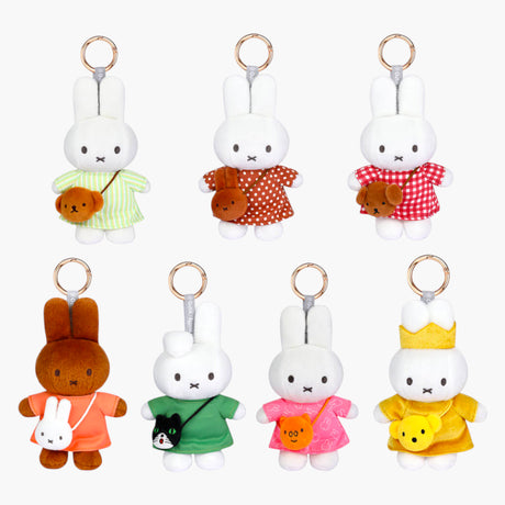 Seven bunny plush keychains in colorful outfits holding small animal-shaped crossbody bags on white background