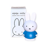 The Miffy Bunny - Blue Money Box 12cm, crafted by the brand Miffy, sits elegantly beside its packaging adorned with the same delightful bunny design. This charming decorative item enhances any space while promoting early money management skills.